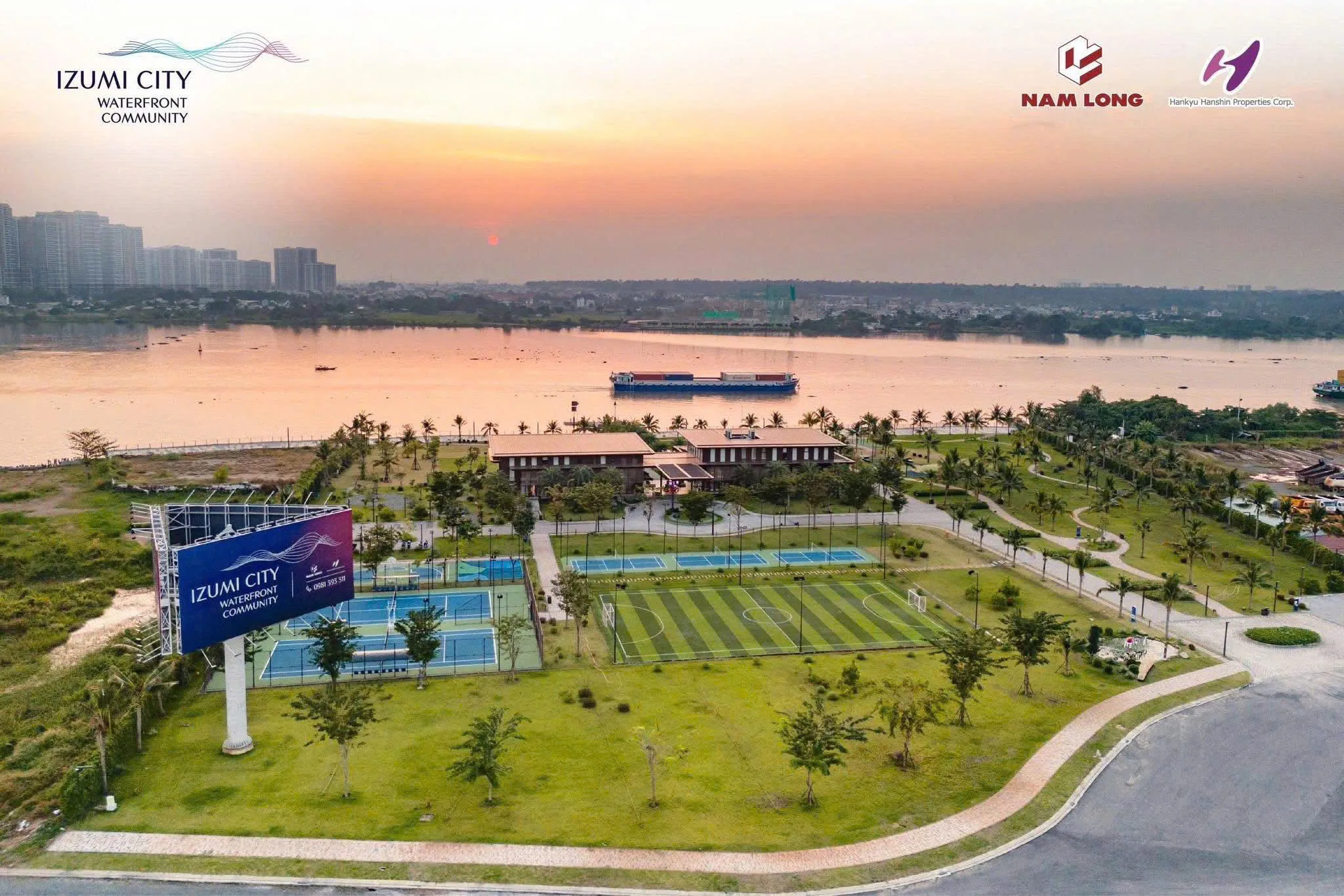 Ảnh thực tế sân thể thao và bảng hiệu Izumi City, phía xa là sông Đồng Nai